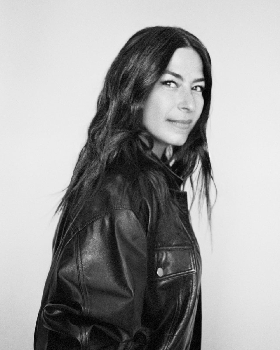Black and white portrait of a woman wearing a leather jacket.
